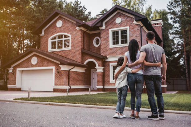 a group of people standing in front of a house a group of people standing in front of a house